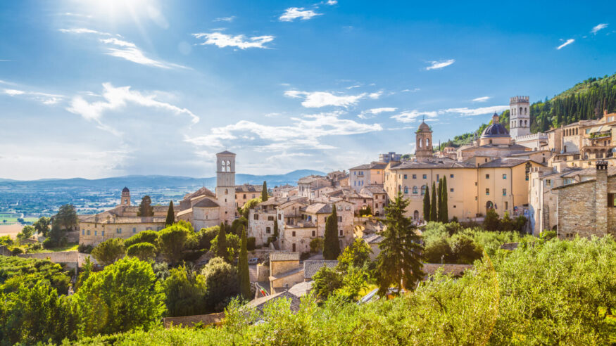 Panoramic view of the historic town of Assisi on a beautiful sunny day with blue sky and clouds in summer, Umbria, Italy.