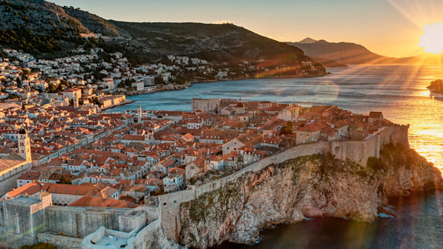 Photo shows beautiful sunrise at Dubrovnik old town. Photo also shows the blue sea and old town wall where the sunlights turned the town in golden color.